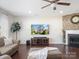 Comfortable living room with hardwood floors, a fireplace with brick accent wall, and large windows at 79411 Ridgehaven Rd, Indian Land, SC 29720