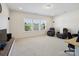 Beige living room with a wall of windows and featuring dark leather recliners and light carpet at 79411 Ridgehaven Rd, Indian Land, SC 29720