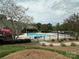 Beautiful community pool with ample seating surrounded by lush landscaping and a pond at 9305 Four Mile Creek Rd, Charlotte, NC 28277