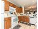 Classic kitchen features wood cabinets, white appliances, and a view into the living room at 9305 Four Mile Creek Rd, Charlotte, NC 28277