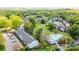 Complex aerial showing lush landscaping, mature trees, parking, and a community pool at 10967 Harrowfield Rd, Charlotte, NC 28226