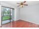Bedroom featuring hardwood floors, a ceiling fan, and a sliding glass door to a balcony at 10967 Harrowfield Rd, Charlotte, NC 28226