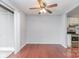 Hardwood-floored living room with sliding glass door, ceiling fan, and view of the kitchen appliances at 10967 Harrowfield Rd, Charlotte, NC 28226