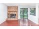 Living room showcasing a brick fireplace, sliding glass doors, and hardwood flooring at 10967 Harrowfield Rd, Charlotte, NC 28226