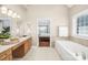 Bright bathroom with double sinks, soaking tub and an open doorway to the bedroom at 1103 Hillcrest Ridge Dr, Salisbury, NC 28146
