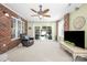 Cozy sunroom with brick accent wall, large windows, ceiling fan, and sliding doors to backyard at 1103 Hillcrest Ridge Dr, Salisbury, NC 28146