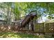 Backyard featuring a wooden deck with staircase, fenced yard and mature trees at 1121 N Alexander St, Charlotte, NC 28206