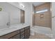Modern bathroom featuring double sink vanity with solid surface counter, tub, and tiled shower at 1121 N Alexander St, Charlotte, NC 28206