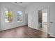 Bright bedroom with large windows, wood floors, and adjacent bathroom access at 1121 N Alexander St, Charlotte, NC 28206