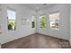 Well-lit bedroom featuring hardwood floors and three windows at 1121 N Alexander St, Charlotte, NC 28206