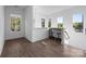 Bright living room features hardwood floors, multiple windows, and a bar-height table with seating for entertaining at 1121 N Alexander St, Charlotte, NC 28206