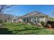 Expansive backyard showcasing the rear of the house, a lush lawn, landscaping, and mature trees at 115 Keswick Ln, Mooresville, NC 28117
