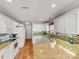 Open kitchen with white appliances, granite counters, tiled backsplash, and wooden flooring at 115 Keswick Ln, Mooresville, NC 28117