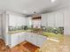 Bright kitchen featuring granite countertops, white cabinets, tiled backsplash, and stainless steel dishwasher at 115 Keswick Ln, Mooresville, NC 28117