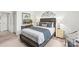 Inviting bedroom featuring neutral tones, a queen bed, and accent decor above the headboard at 12357 Copper Mountain Blvd, Charlotte, NC 28277
