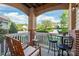 Cozy covered porch featuring comfortable seating and charming brick accents with a pleasant neighborhood view at 12357 Copper Mountain Blvd, Charlotte, NC 28277
