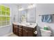 Well-lit bathroom features a double sink vanity, a large mirror and tiled floors at 12746 Bravington Rd, Huntersville, NC 28078