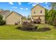Rear exterior view of home showing backyard, deck, detached garage, and well-kept landscaping at 12746 Bravington Rd, Huntersville, NC 28078
