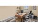 Well-lit home office space with wood desk, shelving, computer and stylish gray and white flooring at 12746 Bravington Rd, Huntersville, NC 28078