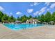 Large community pool with ample seating, a clubhouse, and mature trees on a sunny day at 12746 Bravington Rd, Huntersville, NC 28078