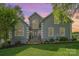 Charming two-story home with stone accents, a well-manicured lawn, and beautiful landscaping at 130 Hopedale Ct, Mooresville, NC 28117