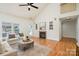 Cozy living room featuring hardwood floors, fireplace, and a vaulted ceiling with fan at 130 Hopedale Ct, Mooresville, NC 28117