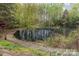 Scenic view of a serene pond surrounded by lush greenery and a wooden staircase at 130 Hopedale Ct, Mooresville, NC 28117