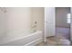 A white bathtub in a bathroom with a doorway to a carpeted room at 1430 Eastway Dr, Dallas, NC 28034