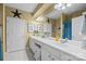 Bright bathroom with double vanity sinks, white cabinets, and neutral tile flooring at 14869 Santa Lucia Dr, Charlotte, NC 28277