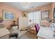 Cozy bedroom with soft peach walls, a plush armchair, and a decorative chandelier at 14869 Santa Lucia Dr, Charlotte, NC 28277