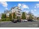 Exterior view of a multi-story condo building with manicured landscaping and ample parking at 14869 Santa Lucia Dr, Charlotte, NC 28277