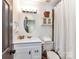 Bright bathroom features a modern vanity, updated fixtures, oval mirror, and shower with white curtain at 1568 Cleveland Ave, Charlotte, NC 28203