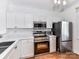 Modern kitchen featuring white cabinets, stainless steel appliances, and countertops, offering a clean and stylish design at 1568 Cleveland Ave, Charlotte, NC 28203