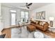 Inviting living room featuring a leather sofa, ottoman, ceiling fan, and stylish decor on wood flooring at 1568 Cleveland Ave, Charlotte, NC 28203