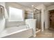 Bright bathroom featuring a soaking tub under a window and a glass-enclosed shower with tile surround at 1588 Trentwood Dr, Fort Mill, SC 29715