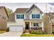 Charming two-story home with a well-manicured lawn, inviting front porch, and pleasing architectural details at 1588 Trentwood Dr, Fort Mill, SC 29715