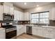 Modern kitchen featuring white cabinets, stainless steel appliances, and a bright window at 1588 Trentwood Dr, Fort Mill, SC 29715
