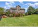 Expansive backyard featuring a well-maintained lawn, garden beds, and a multi-level wooden deck at 16636 Flintrock Falls Ln, Charlotte, NC 28278