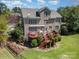 Spacious brick home with a wooden deck, lush green lawn, and garden beds perfect for outdoor living and entertaining at 16636 Flintrock Falls Ln, Charlotte, NC 28278