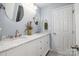 Bathroom featuring double sinks, a marble countertop, and round mirrors at 16636 Flintrock Falls Ln, Charlotte, NC 28278