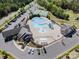Aerial shot of a community pool, splashpad, tennis courts, and parking area with landscaping at 16636 Flintrock Falls Ln, Charlotte, NC 28278