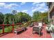 A spacious red wooden deck featuring lounge chairs and plant boxes, surrounded by lush greenery at 16636 Flintrock Falls Ln, Charlotte, NC 28278