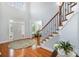 Bright foyer with hardwood floors, staircase with iron railing, and soaring ceilings for an elegant entry at 16636 Flintrock Falls Ln, Charlotte, NC 28278