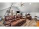 Spacious living room features a large leather couch and a ceiling fan, with a vaulted ceiling at 16636 Flintrock Falls Ln, Charlotte, NC 28278