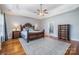 Spacious primary bedroom with trey ceiling, ceiling fan, wood floors, and a decorative rug at 16636 Flintrock Falls Ln, Charlotte, NC 28278