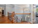 Staircase featuring hardwood steps, wrought iron railings, and bright chandelier at 16636 Flintrock Falls Ln, Charlotte, NC 28278