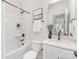 Modern bathroom with shower-tub combo, sleek white vanity, and contemporary black fixtures, exuding elegance at 1706 30Th Avenue Ne Ct, Hickory, NC 28601