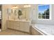 Bright bathroom with double vanity sinks, a soaking tub, and a large window at 1824 Hall Ave, Charlotte, NC 28205