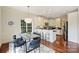 Sunlit dining area with hardwood floors, breakfast bar, modern light fixture, and seamless flow into kitchen at 1824 Hall Ave, Charlotte, NC 28205