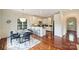 Bright dining area boasts hardwood floors, white walls, and a breakfast bar to the sleek white kitchen at 1824 Hall Ave, Charlotte, NC 28205